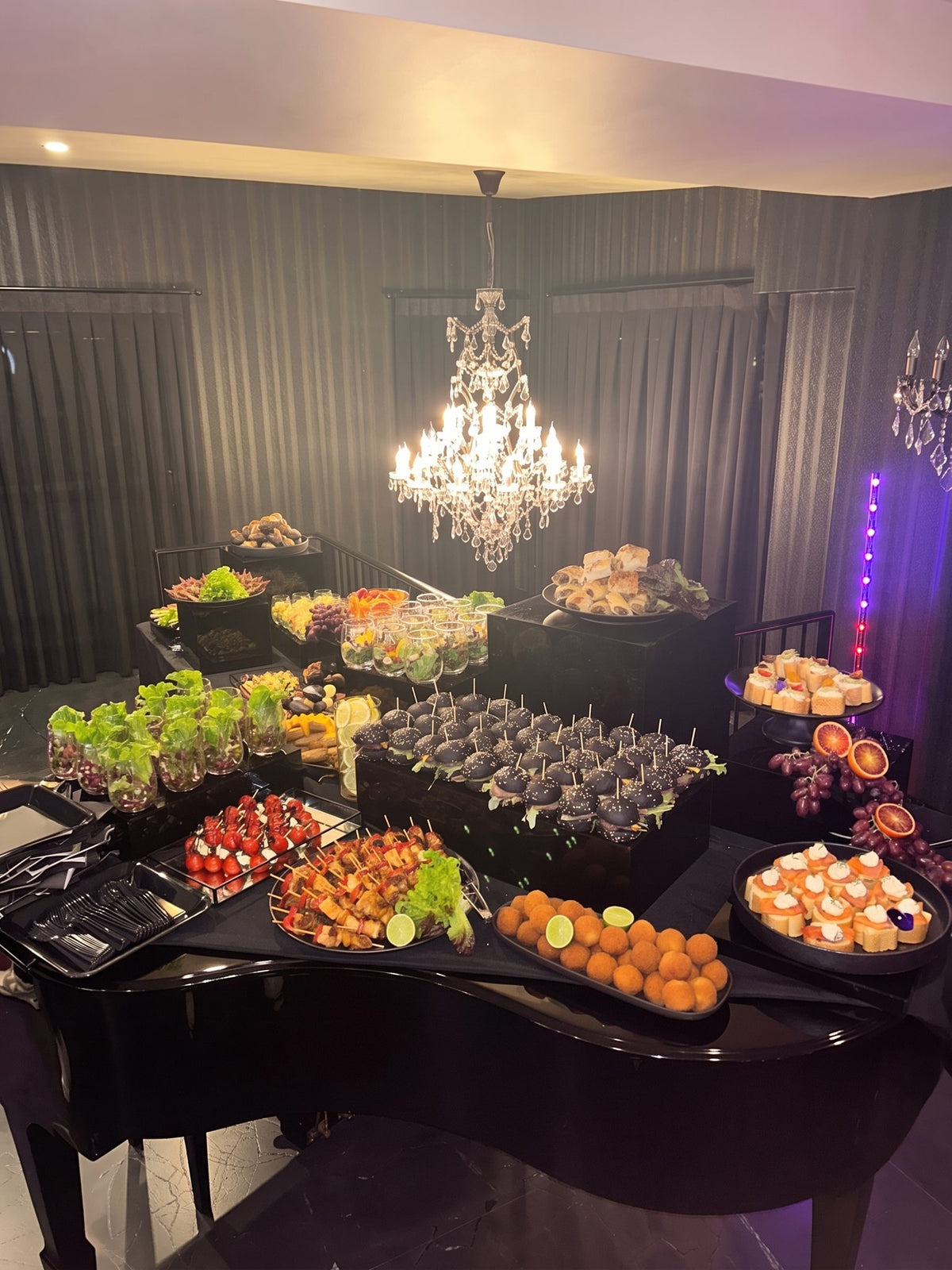 An evening feast laid out under a chandelier